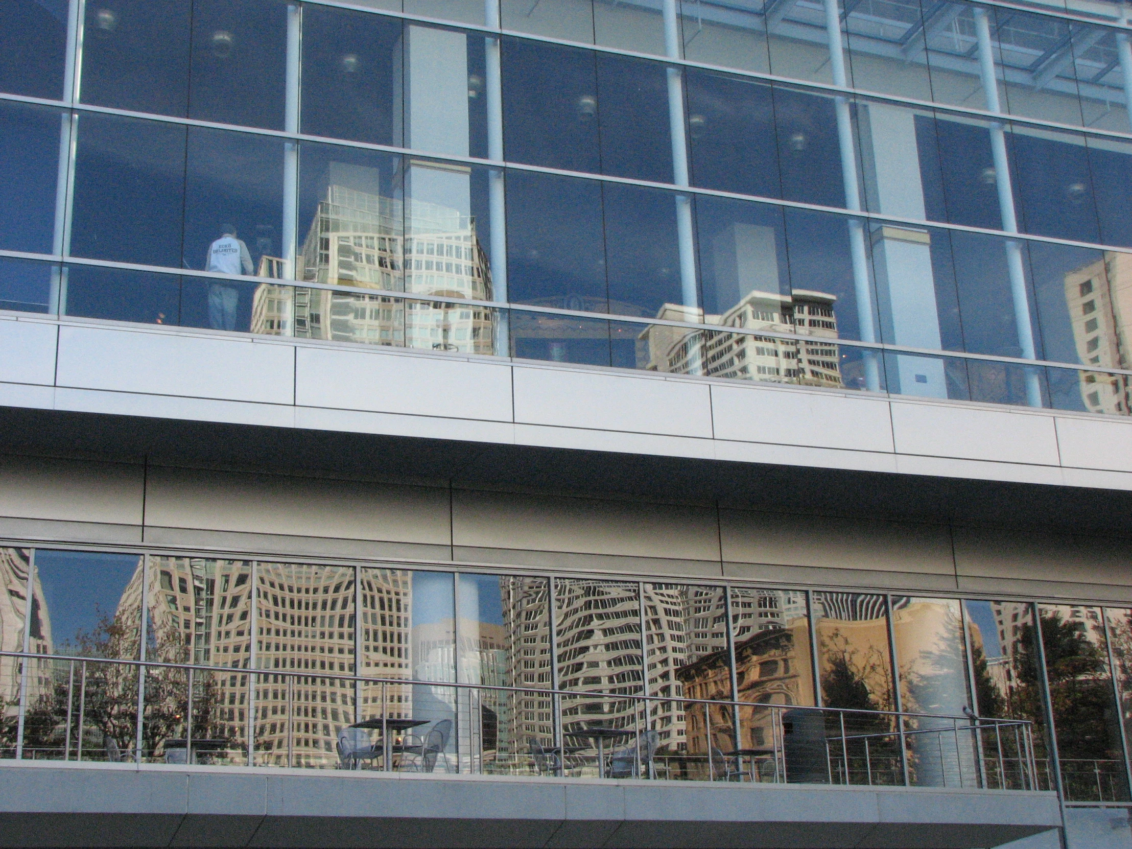 the reflection of buildings in the windows of a modern building