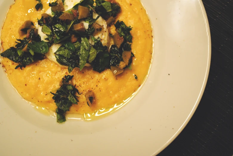 a plate of food with eggs and greens