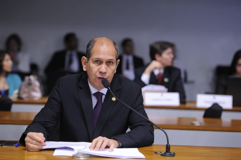 a man in a suit and tie sitting at a table