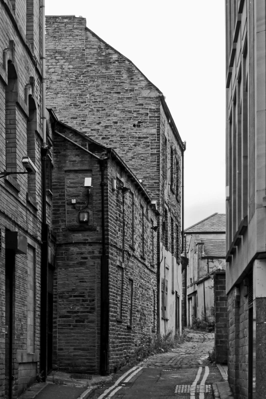 a narrow alley with buildings and brick lined street