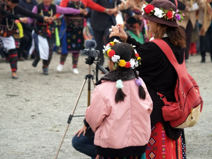 two women wearing hats, one taking a po