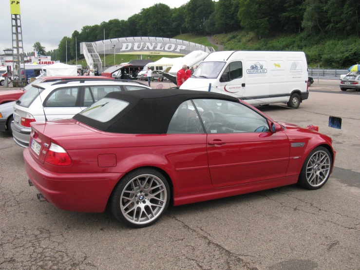 a red bmw car sits in front of other cars