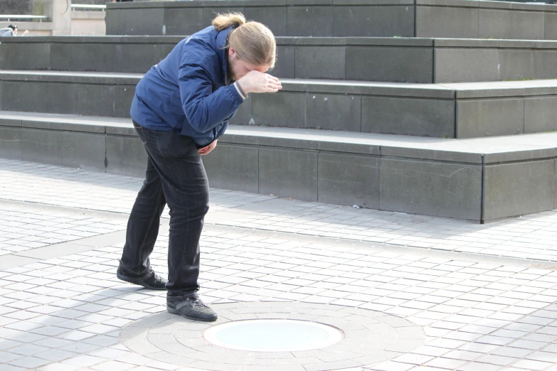 a woman in jacket leaning down next to stairs