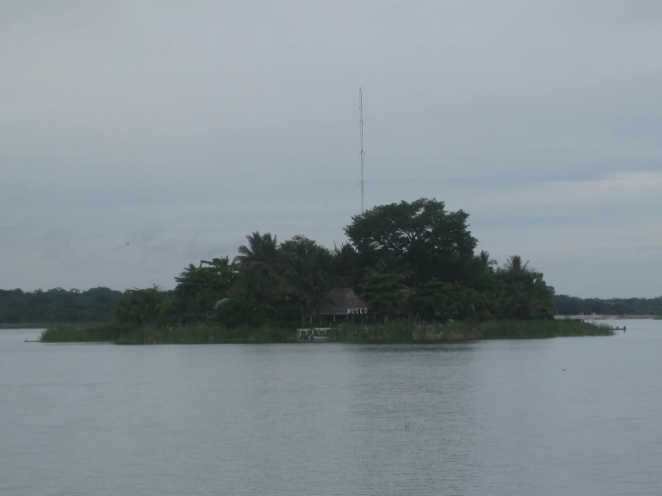 a large body of water with a tree and house on it