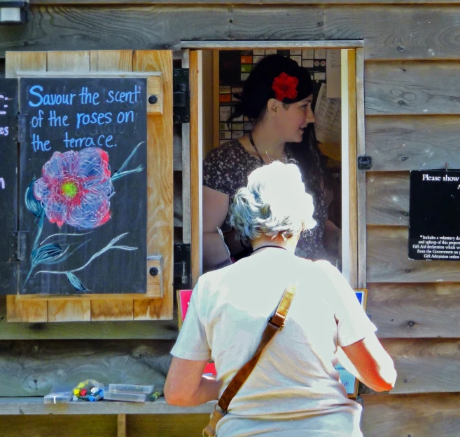 two people standing outside a doorway at a flower shop