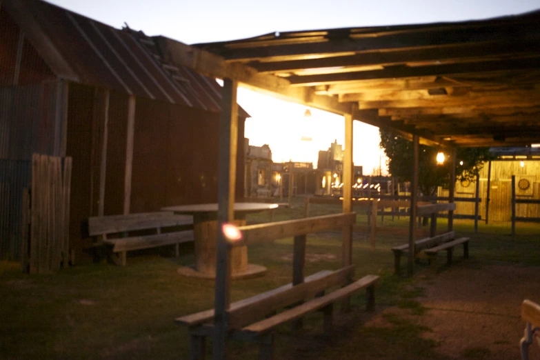 the sun shining through some wooden benches