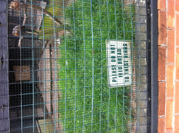 a sign posted in a fence near a building