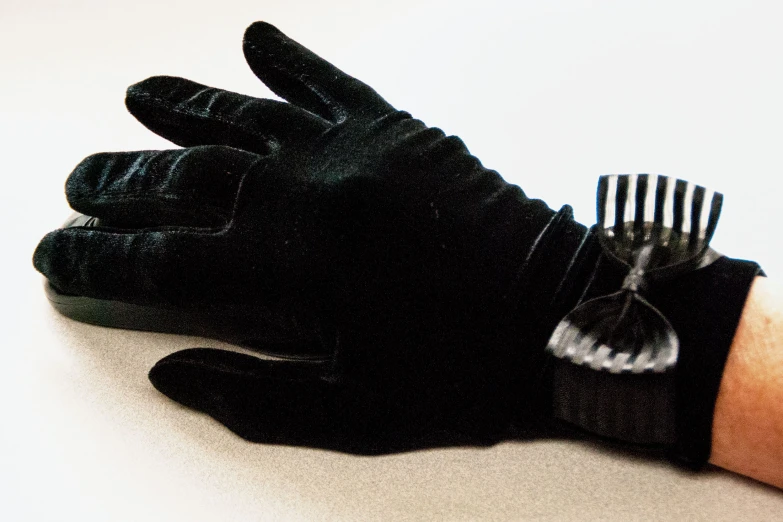 black gloves hold on to a black comb