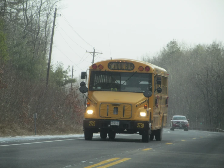 a yellow school bus driving down the road