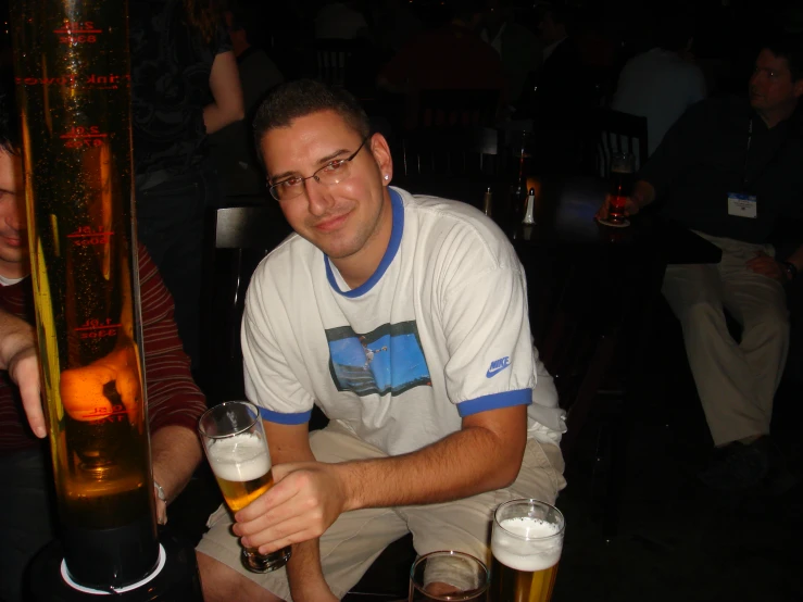 a man sitting with several beers in his hands