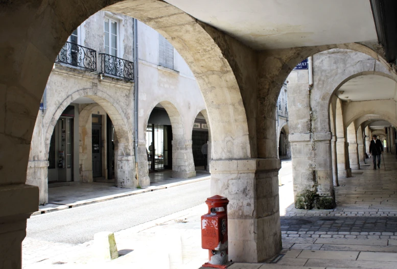 a row of arched stone buildings at an alley