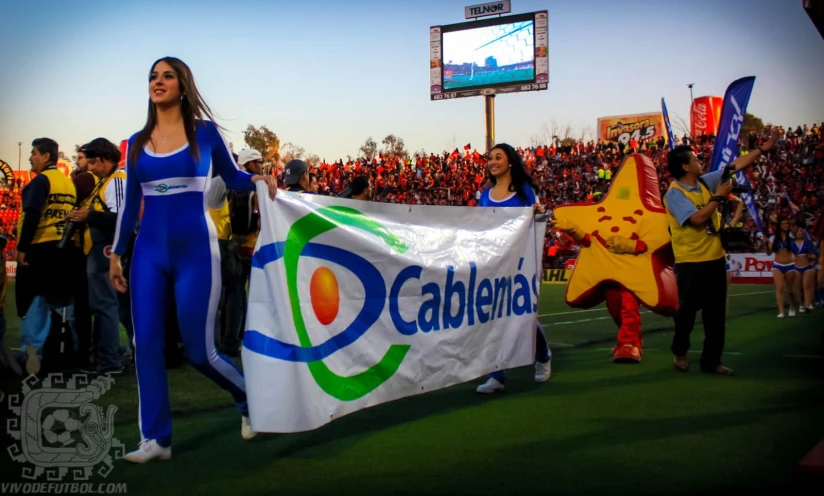 woman in blue clothes and man dressed as superheros holding a pepsi ad flag at an event