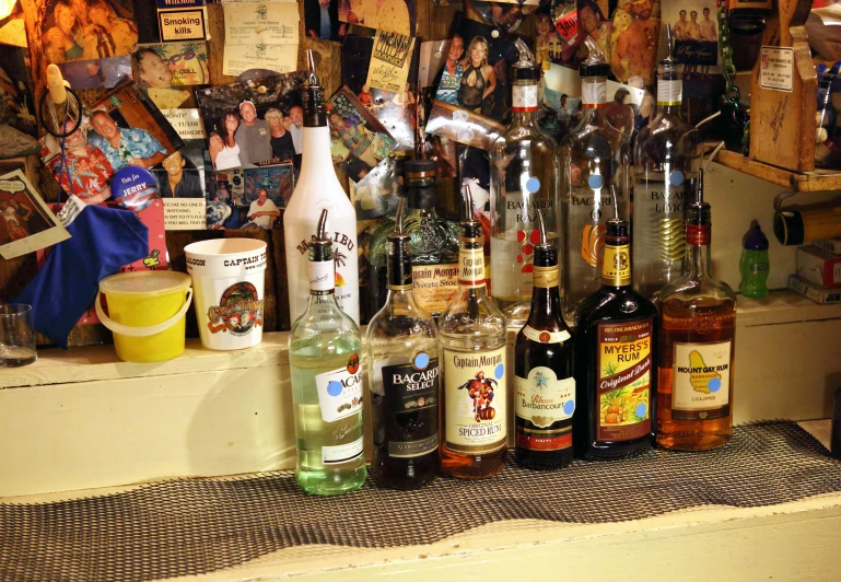 liquor bottles and a glass sit on a bar counter