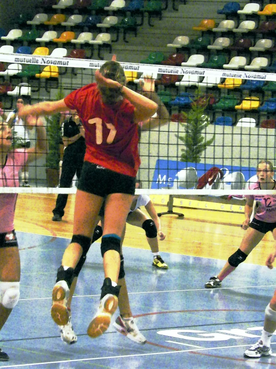 a female volleyball player in a red shirt is doing soing