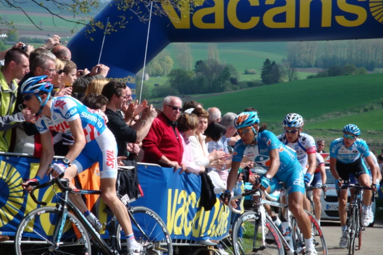 several men ride bikes around on a course