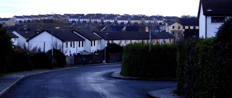 a winding road in the city with houses on either side