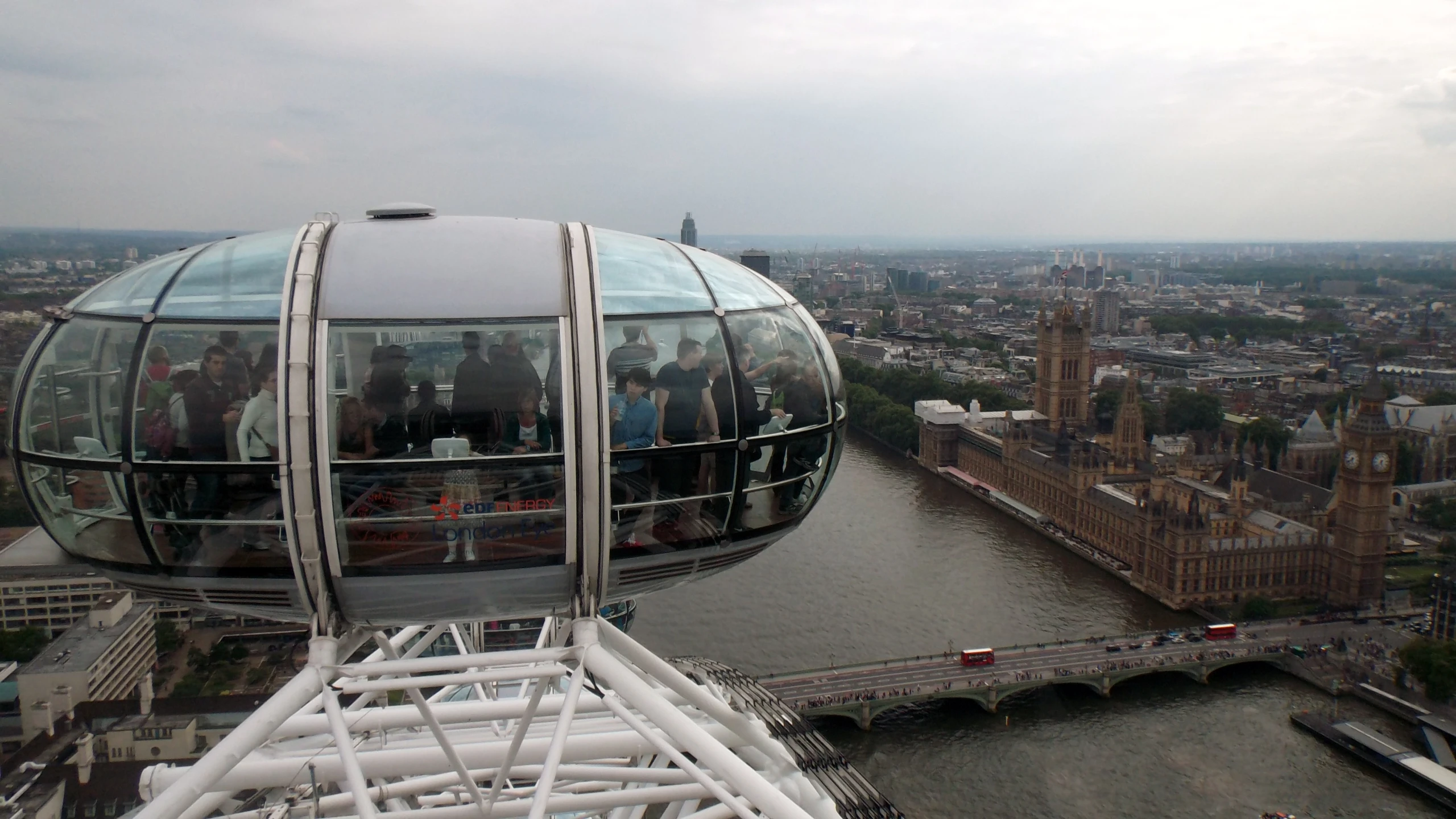 people on the ferris wheel overlooks an urban river