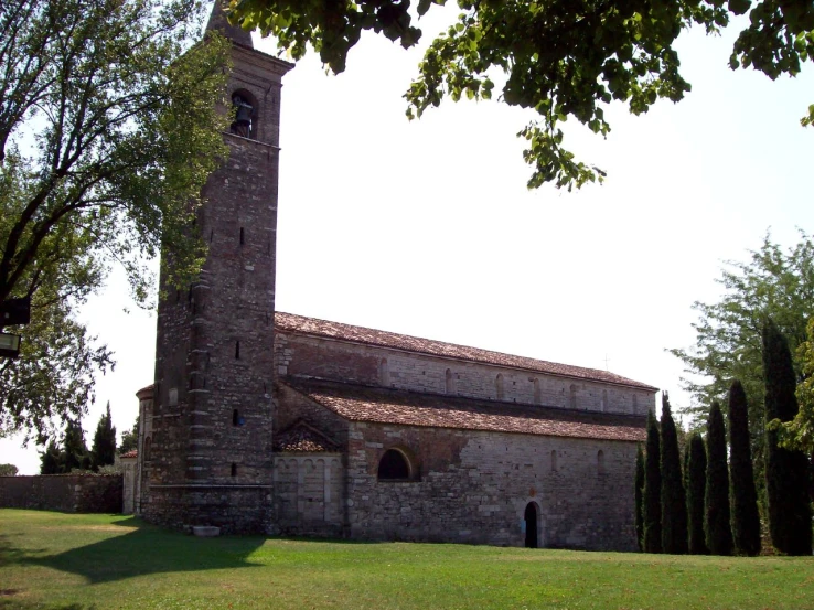 a tall brick tower sits behind an old building