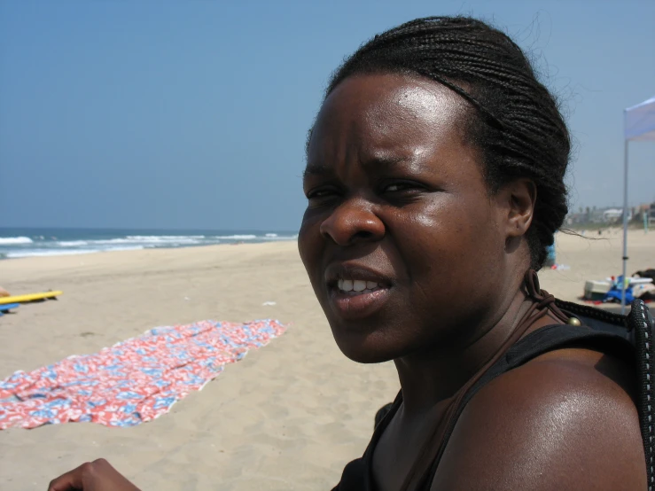 a woman holding an umbrella near the sand of a beach