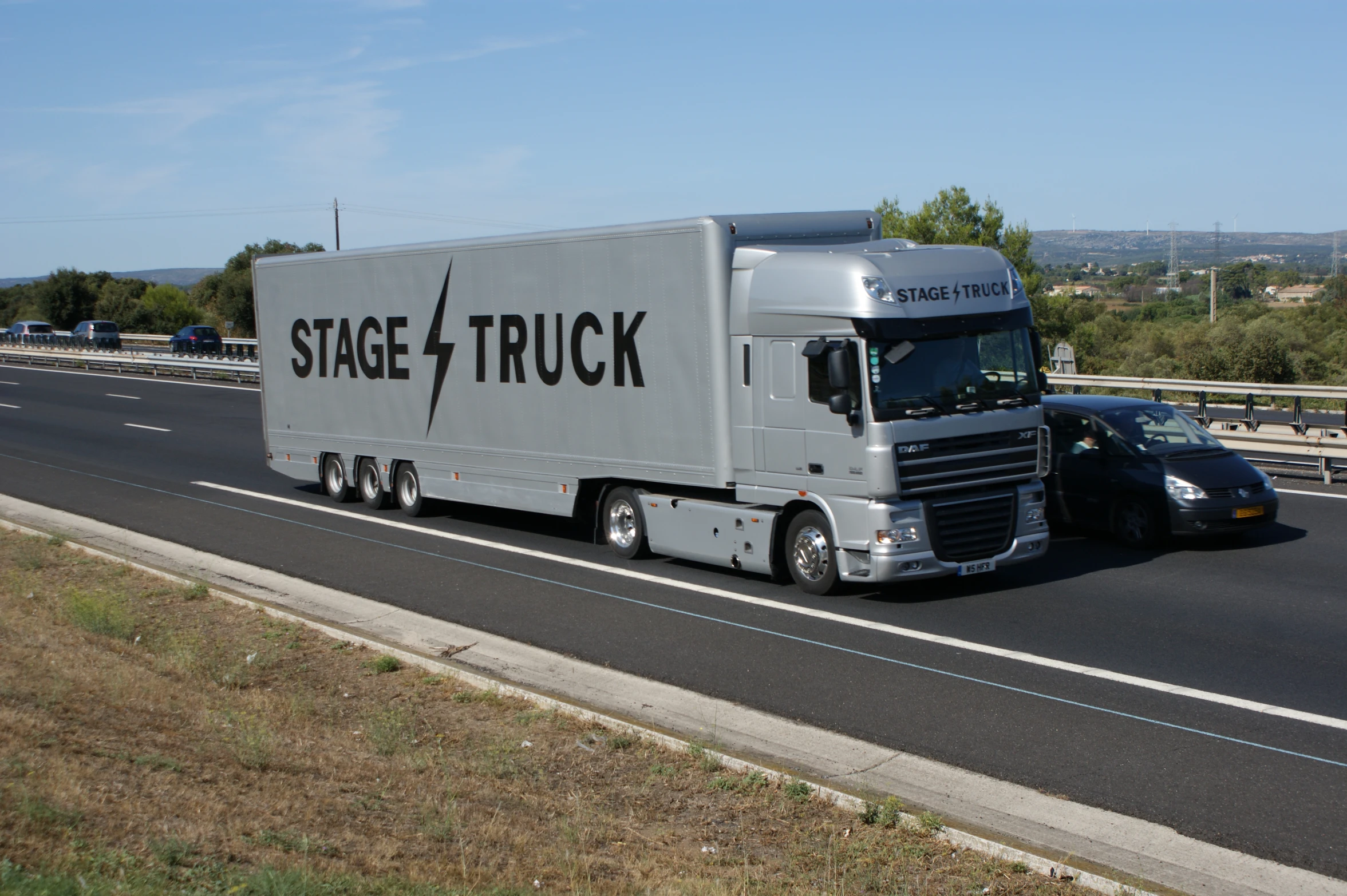 a large gray semi truck traveling down the road