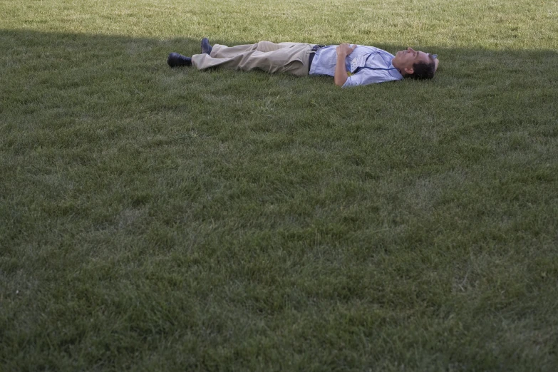 a man that is laying in the grass with his head up