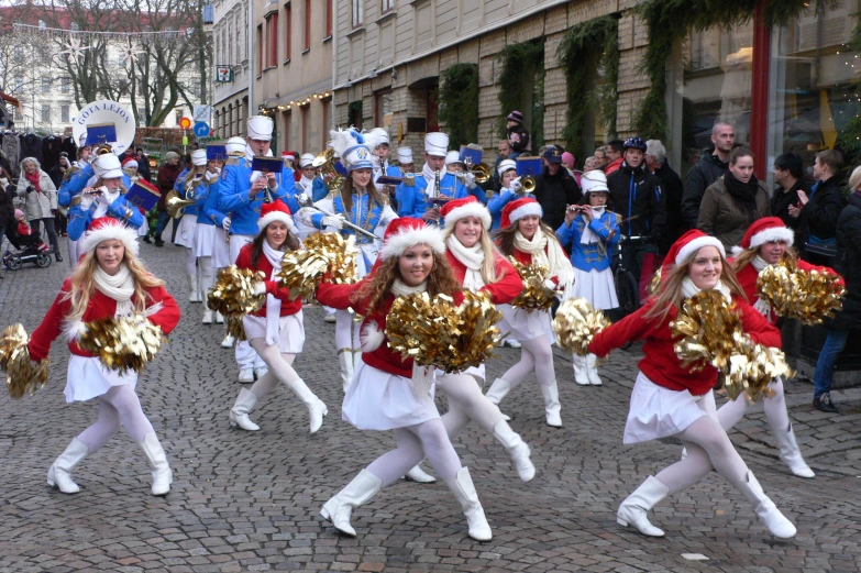 many children dressed in costumes performing on street