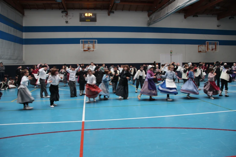 a large group of people in dress clothes performing on a court