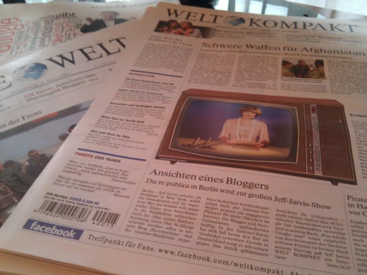 a po of someone on a television displayed in the newspapers