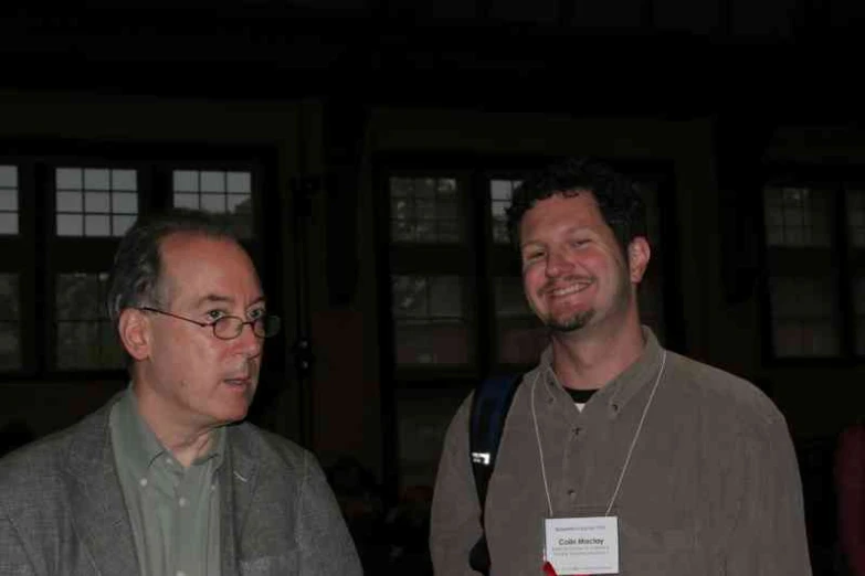 two men standing next to each other laughing