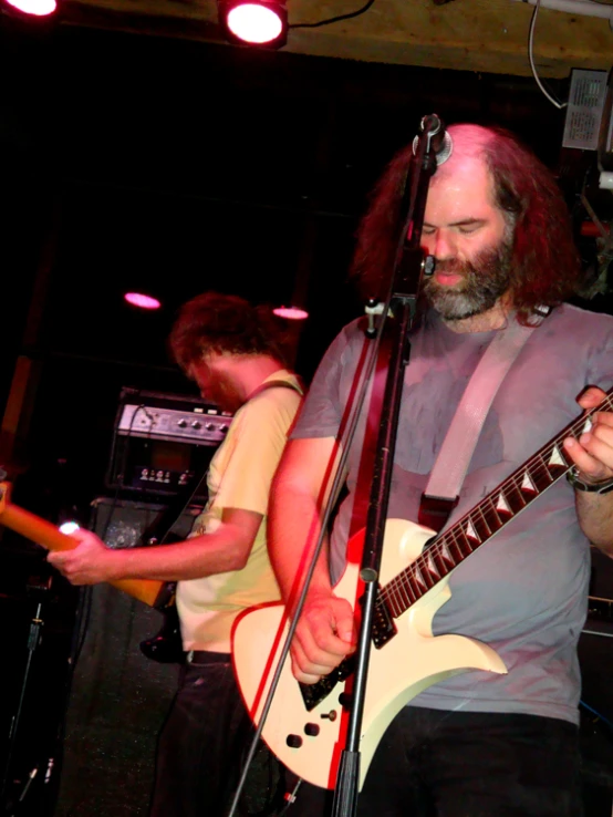 a man playing guitar in front of a microphone