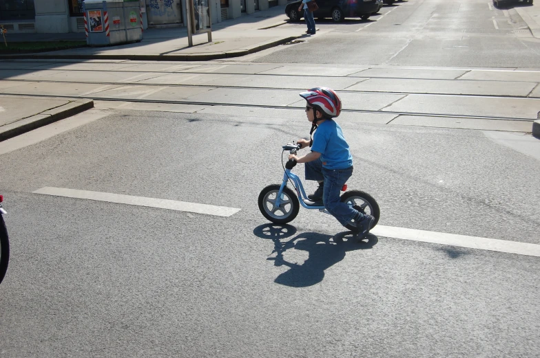a child in a red helmet is riding a small bike