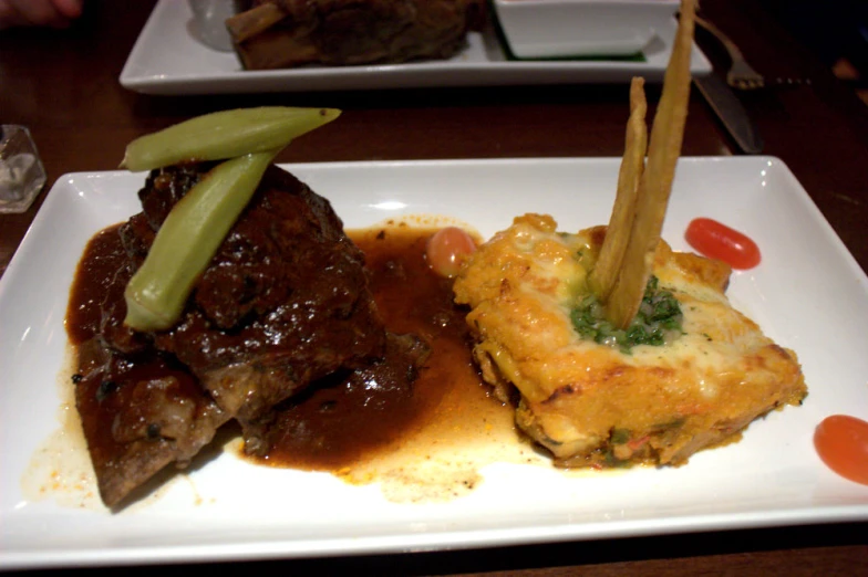 two plates with meat, bread and vegetable on them