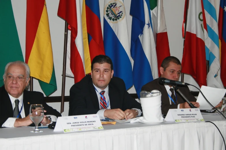 three men sitting at a table with drinks