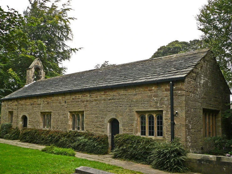 this is a stone building with grass and trees