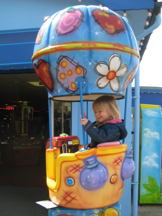 a little girl that is sitting in a machine