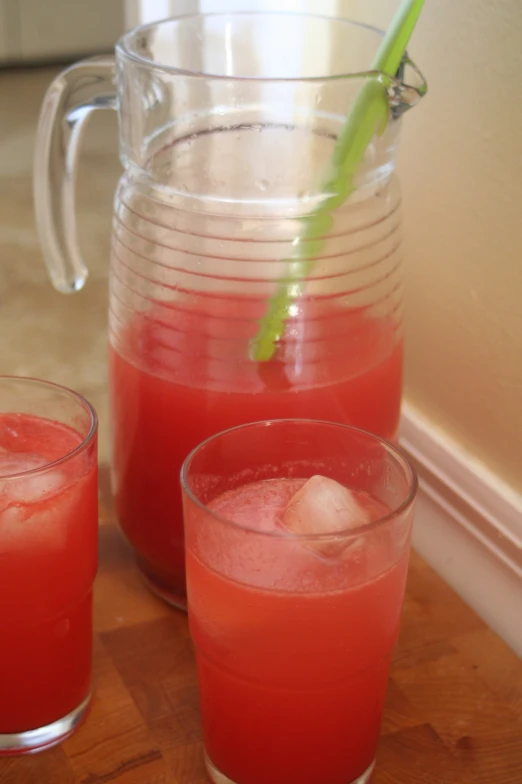 two drinks on a table with water and lime