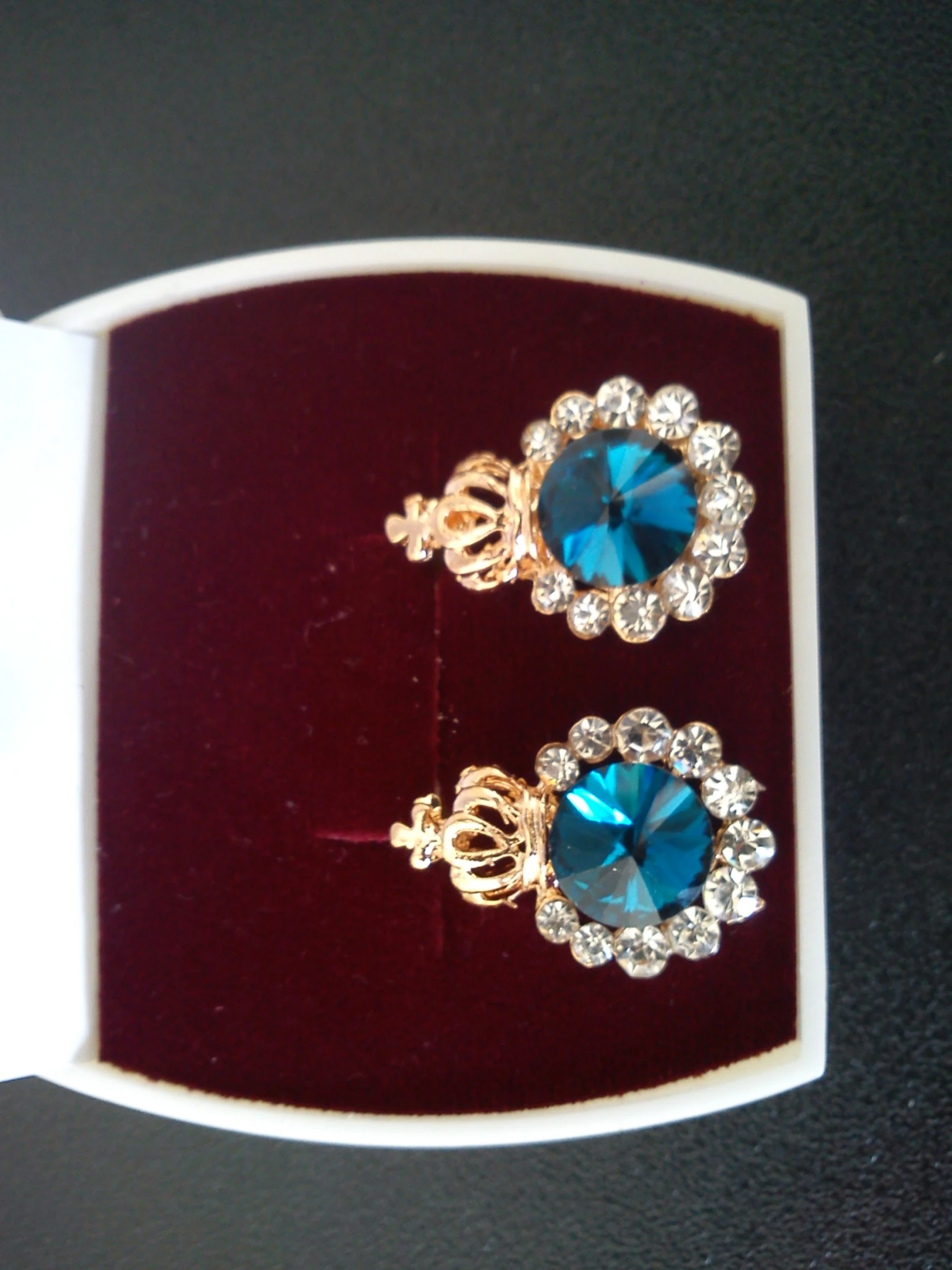 a pair of earrings with diamond trimmings