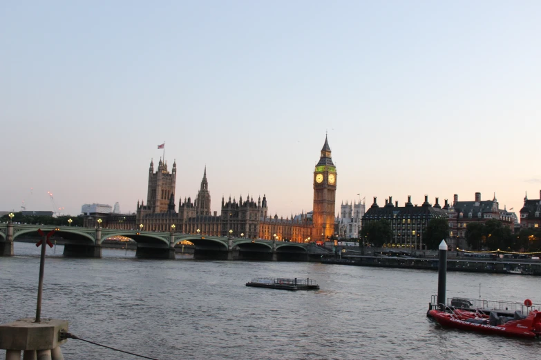 a boat traveling down the river in front of large buildings