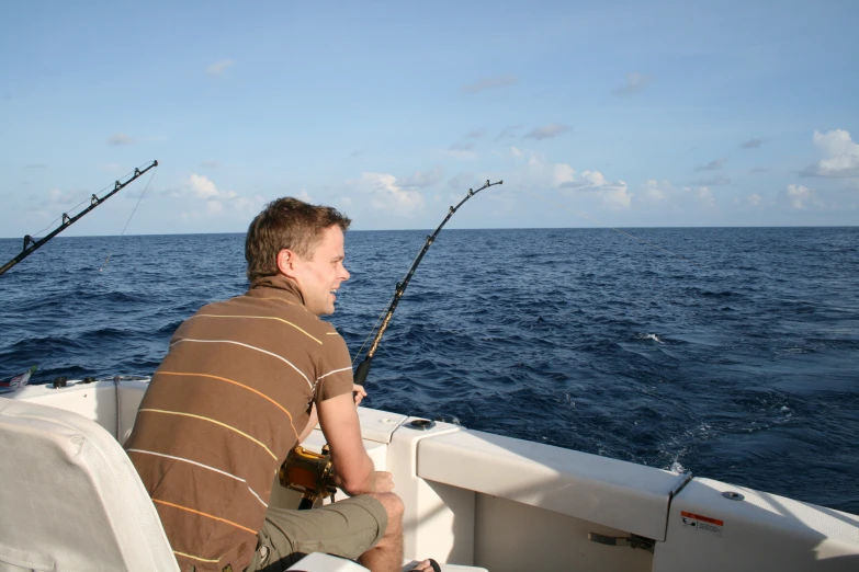 a man on a boat in the middle of a body of water with some fish