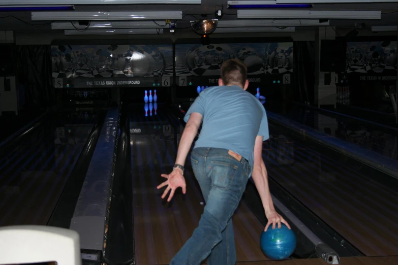 a man is bowling down a pinstripe alley