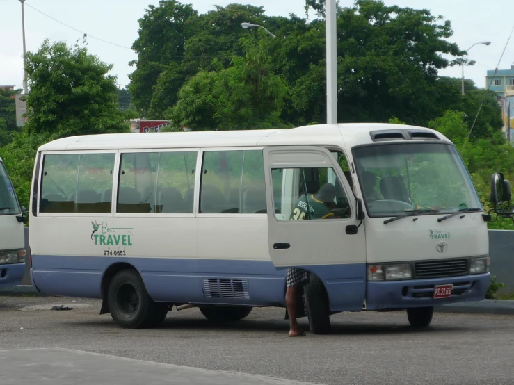 an adult stands by a parked bus