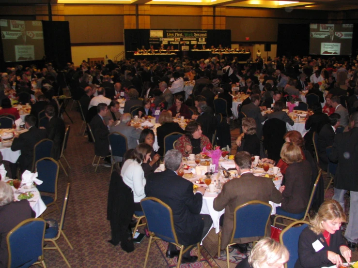 a very large room of people are eating