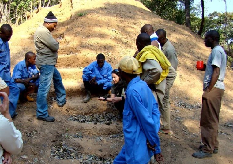 the group of people gather in front of an unfinished structure