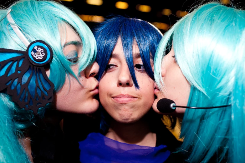 three girls are kissing each other with a green hair