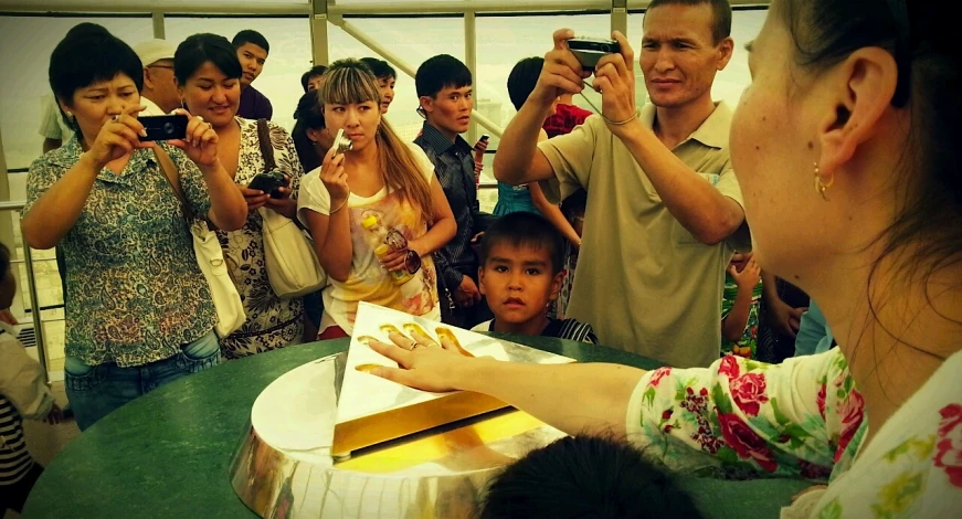 a small group of people are gathered behind a table eating