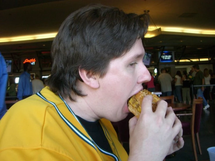 a man eating food inside of a cafeteria