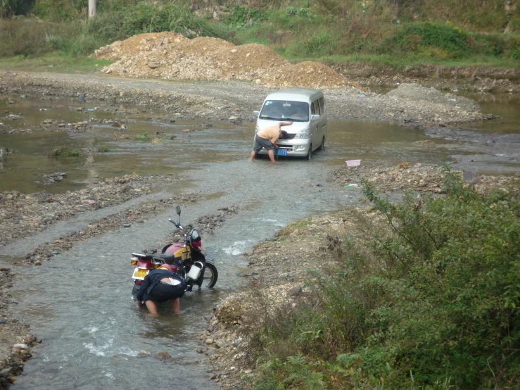 two people ride bikes in the middle of water