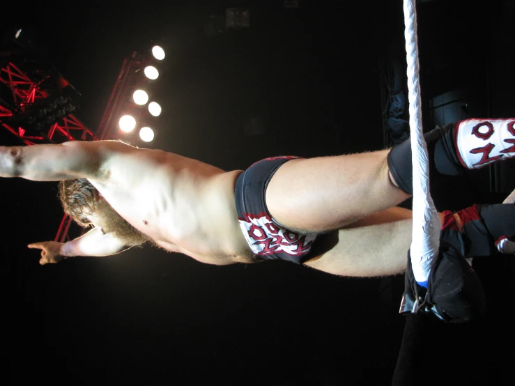 a shirtless man standing in front of a rope