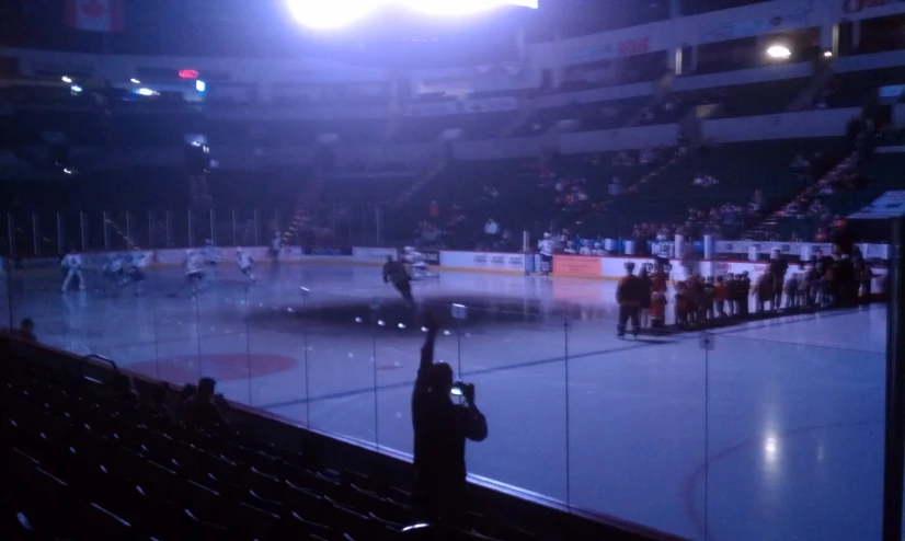 a hockey game on an ice rink with some fans watching