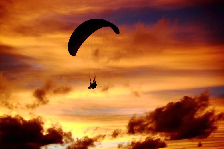 a person para sailing in the air with clouds